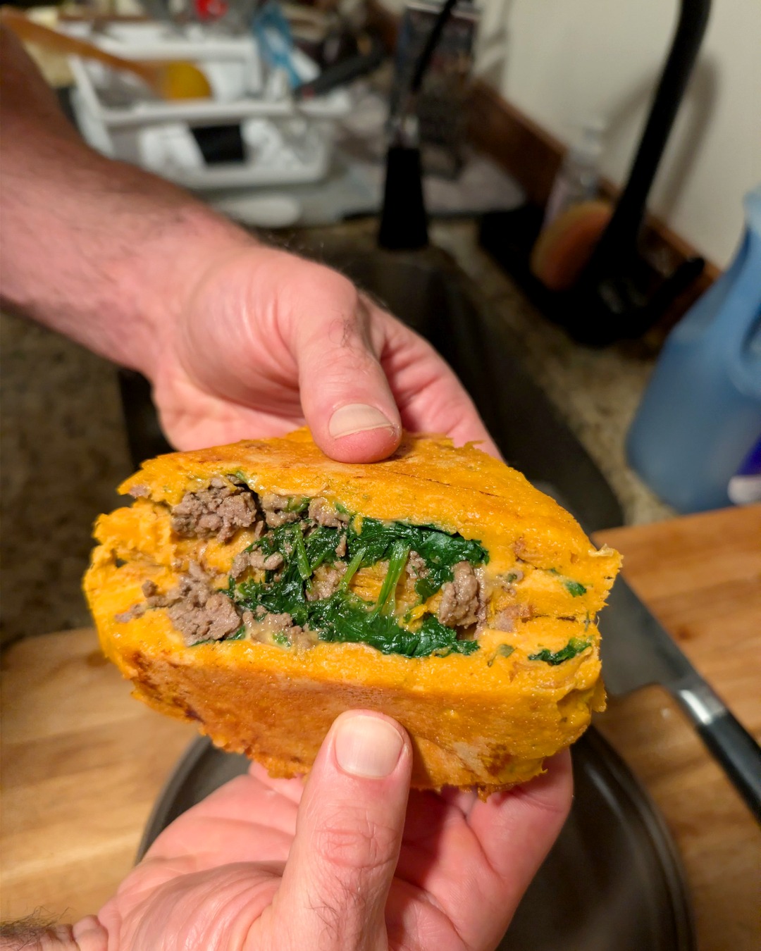A sweet potato beef pocket cut open to show the beef and spinach filling